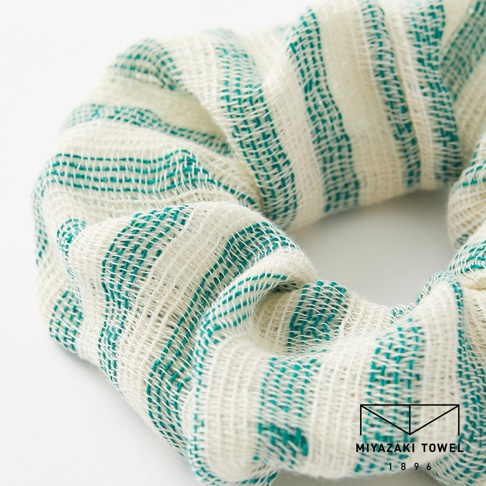 今治有機匹馬棉雙色彈力髮圈，織有綠色細條紋的米白色織物，質地輕柔有彈性。