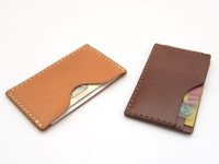 兩個職人手作皮革卡片夾，一個為淺棕色，另一為深棕色，皆以手工縫線製作，邊緣光滑，可收納卡片。