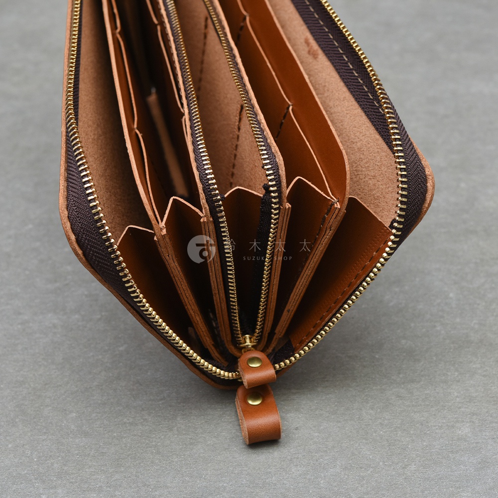 職人手作皮革Organ大容量拉鍊長夾，展示了多個隔層與黃銅色拉鍊細節，材質呈現自然的皮革紋理。