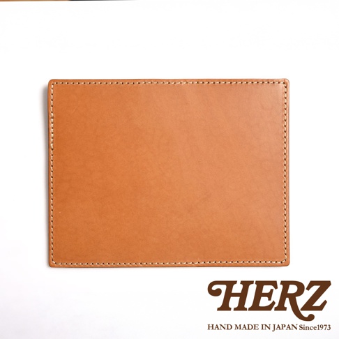 淺棕色皮革輕便記事本書套，邊緣以白色縫線裝飾，簡約設計。