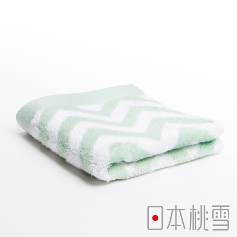 一條淺綠色與白色相間、帶有鋸齒狀圖案的毛巾，材質柔軟，對折放置於白色背景上。