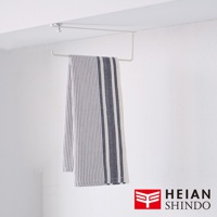 白色金屬製無痕櫥櫃捲紙架，懸掛於櫥櫃上方，下方掛有一條藍白條紋的布巾。