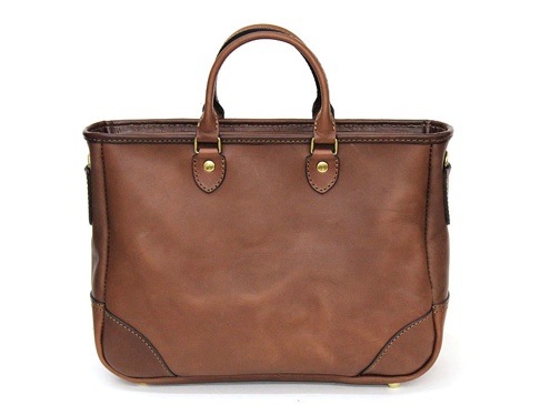 棕色皮革製成的職人手作兩用商務托特包，設有兩個頂部手柄和金屬扣件，包包底部有加固設計。