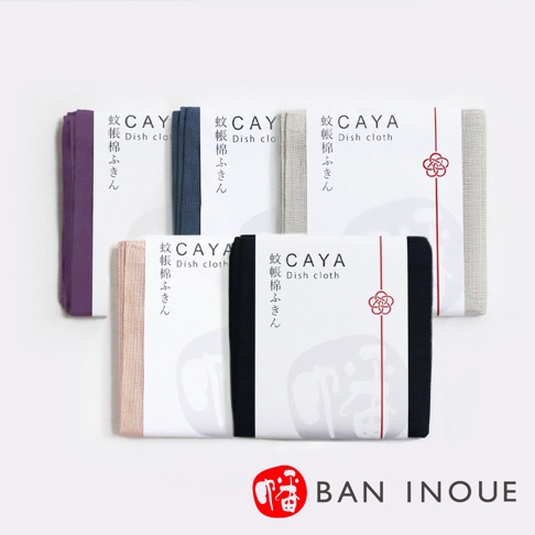 五條不同顏色的兩層蚊帳棉織萬用大拭巾，分別為紫色、藍色、灰色、粉色和黑色，皆以白色包裝紙包裹，上面印有品牌標誌和日文說明。