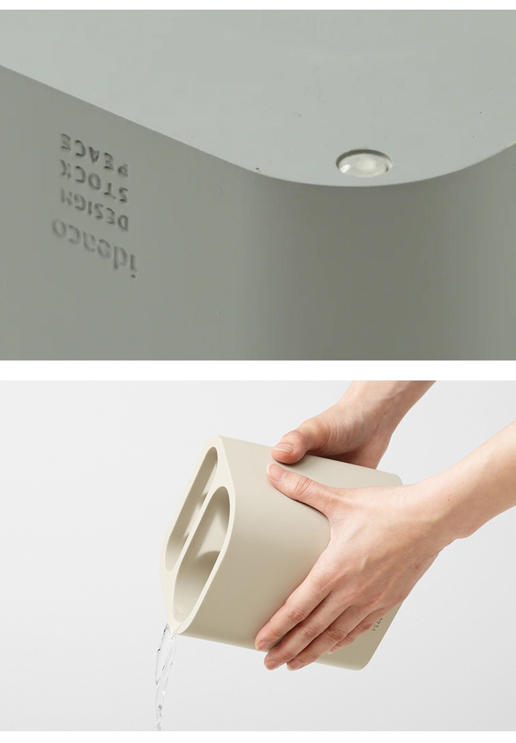 米色簡潔雨傘筒架，雙孔設計，材質為塑料，展示傾斜排水的狀態。