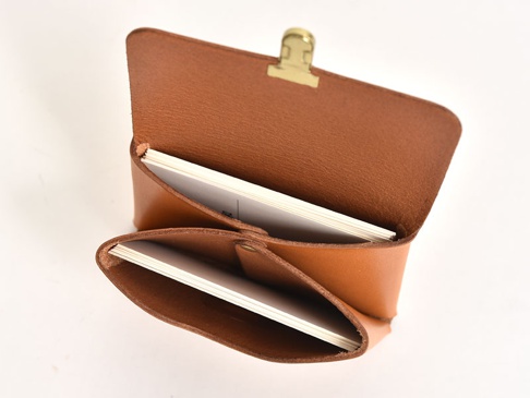 職人手作皮革小卡片收納夾，採用棕色皮革製作，開口處有金色夾子固定，內部可收納數張白色卡片。