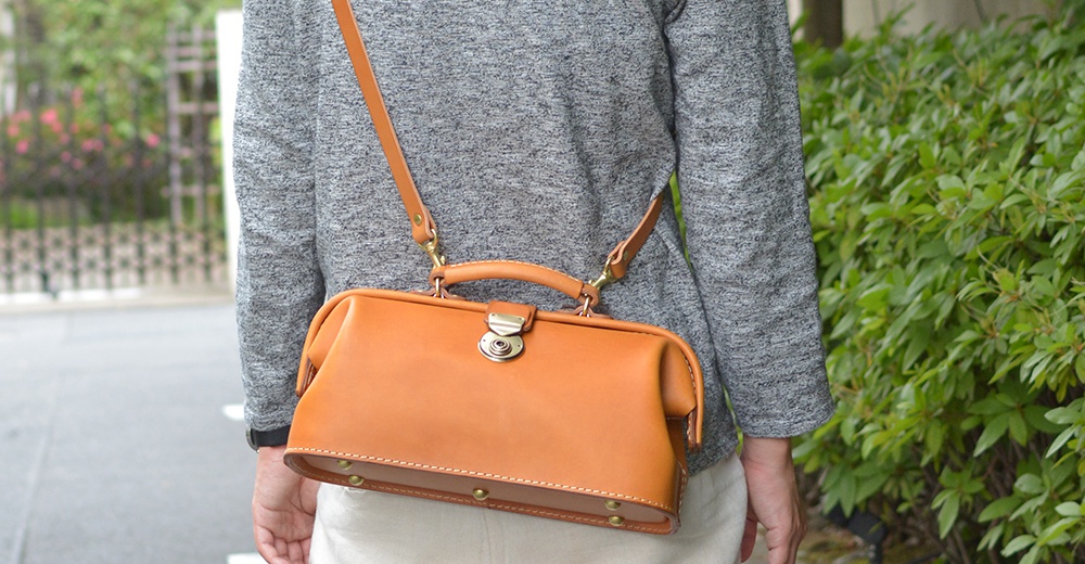 職人手作皮革長型迷你醫生包，經典棕色，精緻縫線，搭配金屬鎖扣及可調式肩帶，展現復古質感。