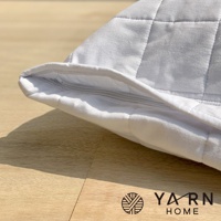 白色格紋枕套，採用脫脂棉混紗材質，帶有拉鍊開口，展示於木質表面。