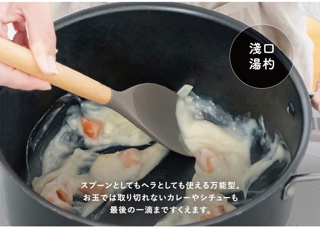 灰色矽膠鍋鏟，配有木質手柄，正在從黑色鍋中舀起濃稠的食物。