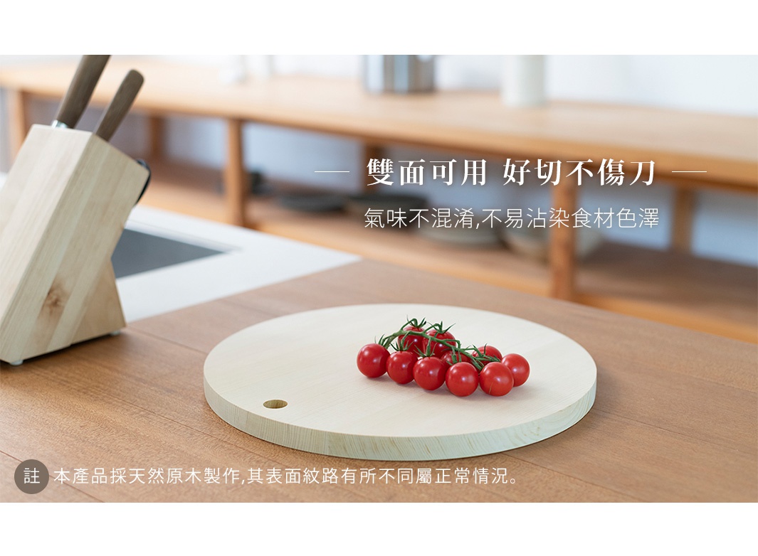 淺色木質圓形砧板，表面有天然木紋，左側有掛孔，上面擺放著一串紅色小番茄。