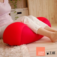 鮮紅色、符合人體工學設計的膝下枕，由柔軟有彈性的布料製成，能支撐腿部，減輕壓力。