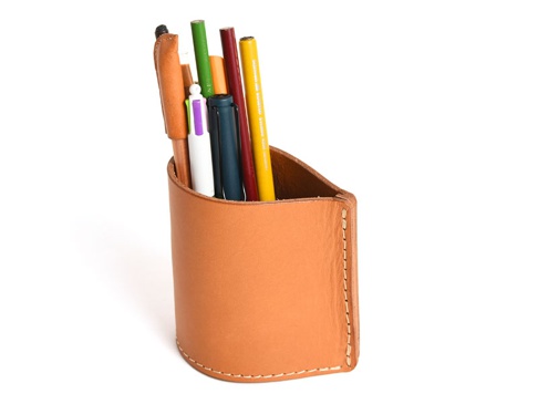 手作皮革筆筒，淺棕色，圓柱形，側面有縫線裝飾，內含多支不同顏色的筆。