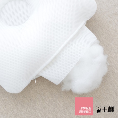 白色網狀織物嬰兒皇冠枕，填充物為蓬鬆棉絮，枕頭部分可見圓形凹陷設計，材質輕柔透氣。