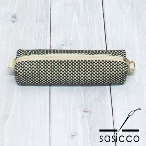 三河木綿刺子織筆袋，黑色與白色格紋織紋，米白色拉鍊，附有金屬拉環。