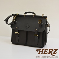 全黑職人手作皮革旅行包，設有雙前袋、可調節肩帶及黃銅色金屬扣環，復古設計，簡約實用。