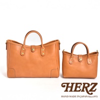 一對淺棕色職人手作皮革迷你托特包，以簡約的設計和精緻的縫線展現皮革質感。