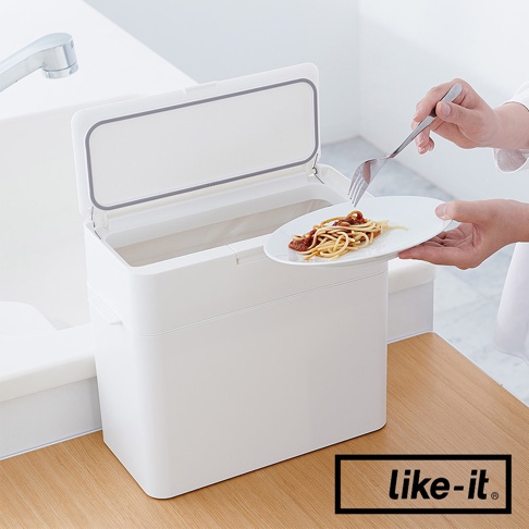 白色塑膠垃圾桶，有按壓式開啟的蓋子，內有塑膠內袋，旁邊有一個盤子，上面放著義大利麵，由人手持叉子準備丟棄。