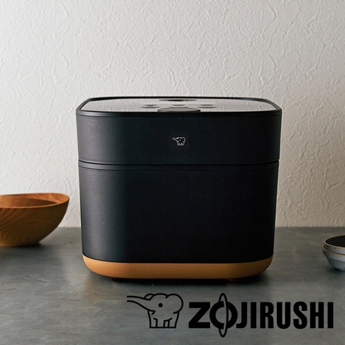 STAN 美型IH微電腦電子鍋NW-SAF10，採用黑色霧面外殼，搭配底部淺棕色烤漆，頂部為光滑黑色面板。產品中央有象印Logo。