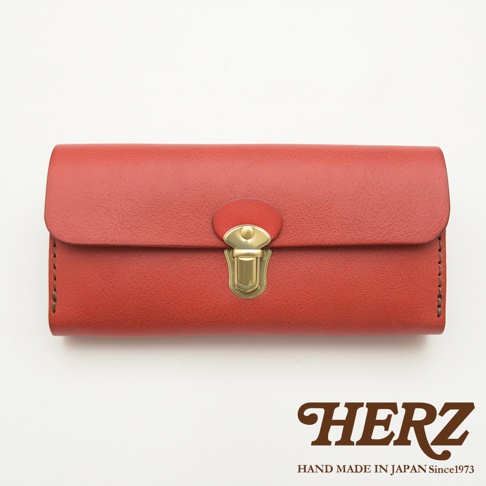 紅色的職人手作皮革長夾，配有金色金屬插銷鎖扣，簡潔的設計展現皮革紋理。