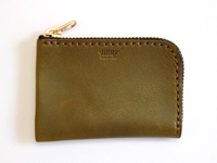 橄欖綠色皮革L型拉鍊卡片收納夾，頂部有金色拉鍊和拉環，皮革表面有細緻紋理，邊緣以咖啡色縫線手工縫製，中央印有「HERZ MADE IN JAPAN」字樣。