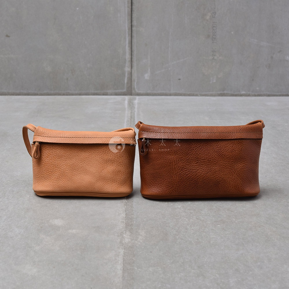 兩個皮質手拿包，一個為淺棕色，另一個為深棕色，皆有拉鍊開合。