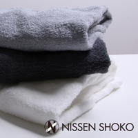 三條堆疊的浴巾，顏色分別為淺灰、深灰和白色，材質為柔軟的毛圈織物。