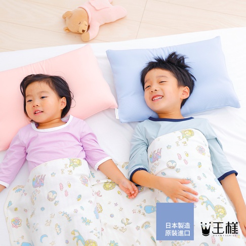 兩個小孩躺在床上，蓋著印有可愛圖案的白色小被子，旁邊是粉色和淺藍色的枕頭。