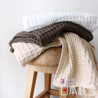 堆疊的今治鬆餅方巾，呈現白色、咖啡色和米白色，皆為柔軟的棉質材質，擁有獨特的格子紋理。