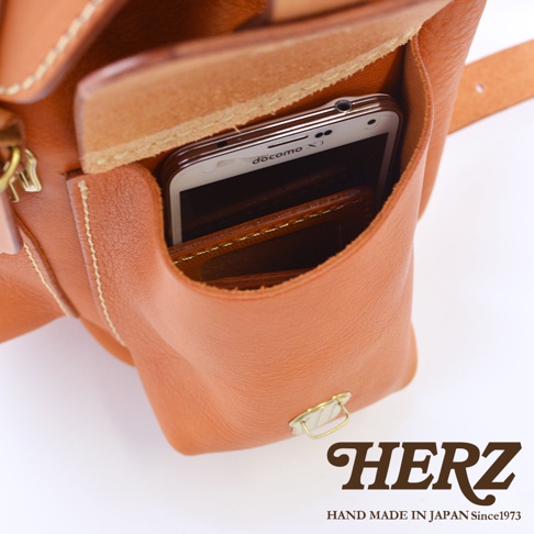 職人手作皮革復古風旅行後背包，棕褐色皮革材質，包包前方有一個外口袋，內有手機和皮夾。