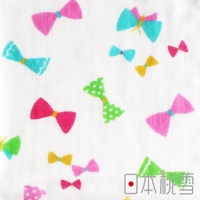 紗布浴巾，白色底布印有粉紅、綠色、蒂芬妮藍及黃色等色系的蝴蝶結圖案，部分蝴蝶結為綠色波點設計，材質為紗布。