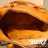 職人手作皮革水洗加工迷你波士頓包，呈現溫暖的焦糖色皮革，內裡為淺棕色皮革，設計有拉鍊開口及內部收納隔層。