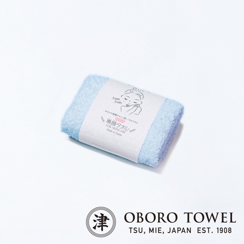 淺藍色三倍吸水專顏洗臉毛巾，材質柔軟，包裝紙上有女性臉部插畫與日文說明「專顏タオル FOR SKINCARE Made in Japan」。