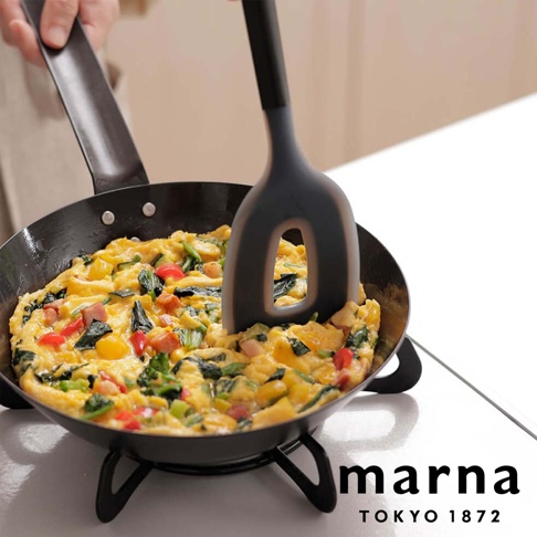 marna TOKYO 1872 標誌旁，一個黑色料理刮刀正在翻動著鍋中的歐姆蛋。