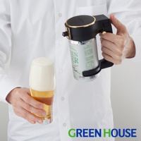 黑色圓形啤酒金泡機，帶有金色裝飾，夾著一罐綠色標籤的啤酒，旁邊是一個裝有啤酒和豐富泡沫的玻璃杯。