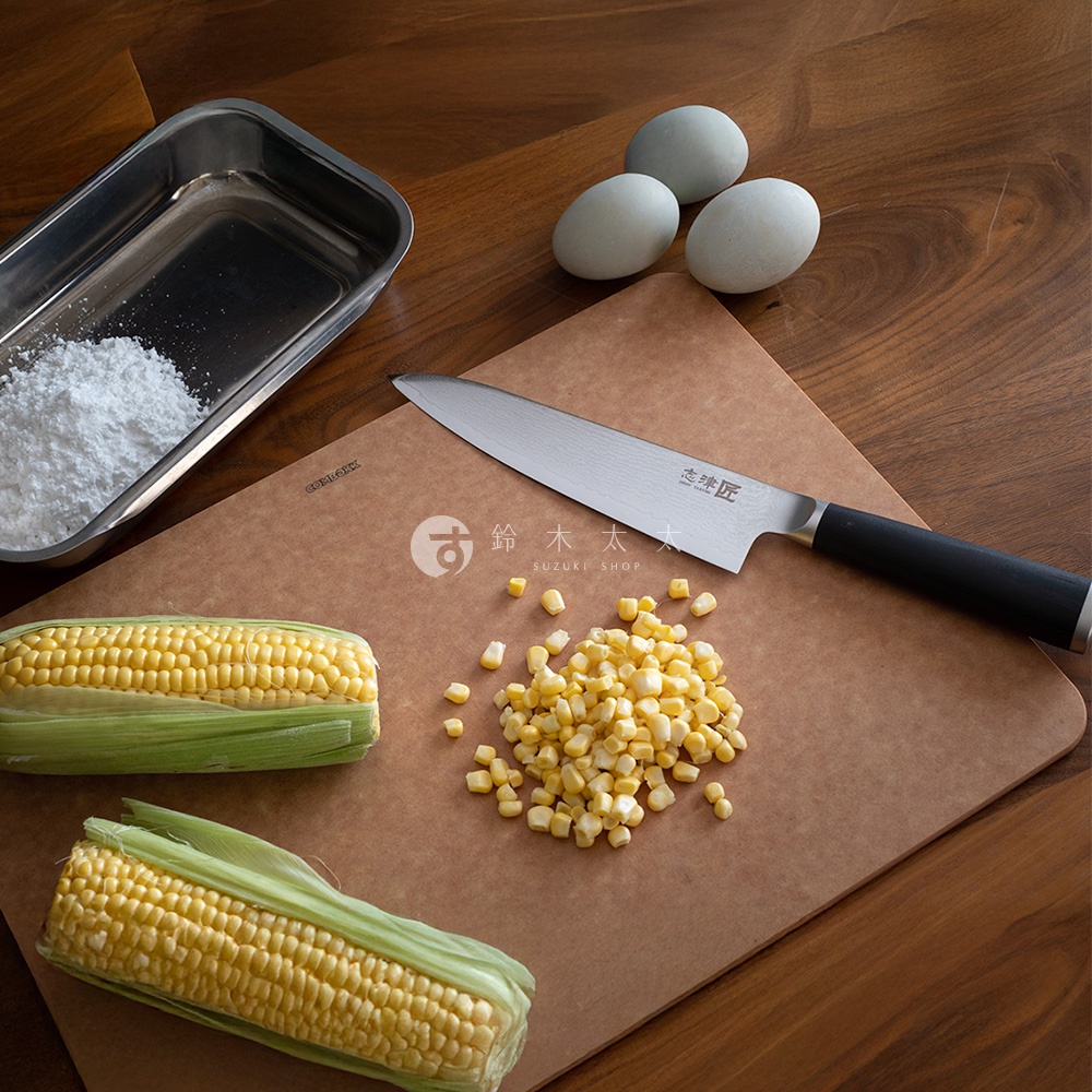 志津匠都水果刀，搭配玉米、雞蛋和白色粉末，在木質桌面和砧板上進行烹飪準備。