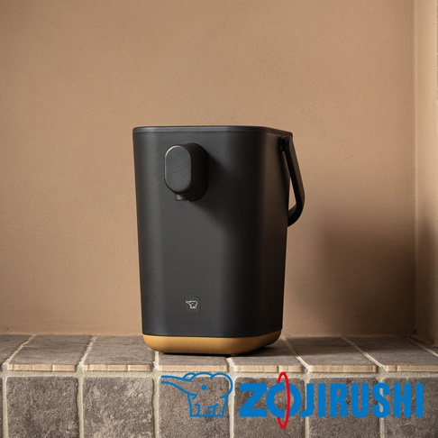 STAN美型微電腦熱水瓶，黑色霧面機身搭配淺棕色底部，設有黑色出水口及提把，機身上有象印品牌標誌。