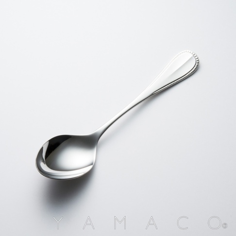 金屬湯匙，湯匙頭有精緻的珠狀邊緣裝飾，湯匙柄光滑，品牌標誌 YAMACO 刻印在下方。