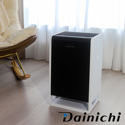 白色邊框搭配黑色格柵面板的HYBRID混合式空氣清淨機，設有Dainichi Plus標誌，放置於木質地板上，背景為白色窗簾。