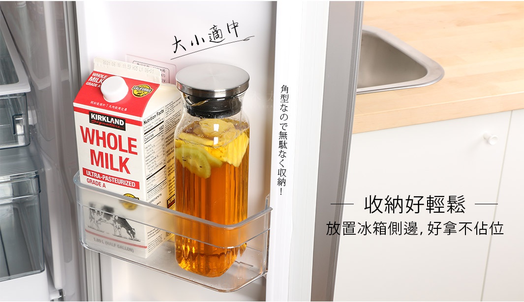 透明耐熱玻璃水壺，內含茶飲與水果切片，搭配不鏽鋼螺旋蓋，放置於冰箱側邊置物架上。