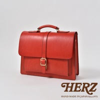 紅色皮革製成的手提後背包，設有單扣和皮帶設計，適合商務使用。
