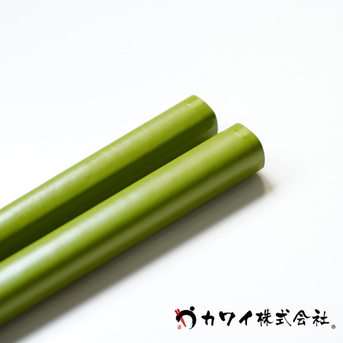 兩支綠色圓形木筷，材質光滑，頂端為圓形。