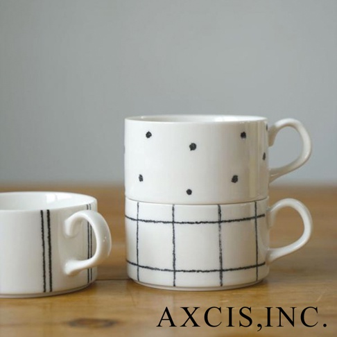 白色美濃燒手繪馬克杯，上方杯子有黑色圓點圖案，下方杯子有黑色格紋圖案，左側另有一個白色馬克杯，杯身繪有黑色垂直線條。