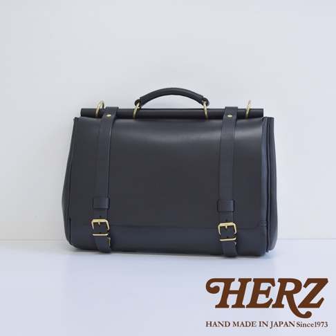 日本 HERZ 職人手作黑色皮革側背包，帶有黃銅色金屬扣環和品牌標誌