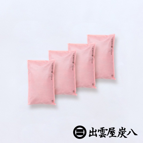 四個粉紅色長方形包裝的出雲屋炭八櫥櫃專用調濕木炭袋整齊排列，袋身採用雙層不織布材質，表面印有品牌名稱與相關標記，右下角配有黑色出雲屋炭八品牌圓形標誌與文字。