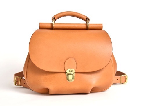 棕褐色皮革製作的迷你後背包，設有翻蓋式開口、金屬鎖扣、頂部提把和可調節式肩帶。
