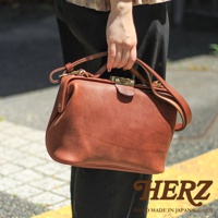 日本HERZ職人手作皮革Organ鎖孔式大開口肩背包 M-7，以其經典的褐色皮革和精緻的鎖孔式開口設計，展現出獨特的復古魅力。