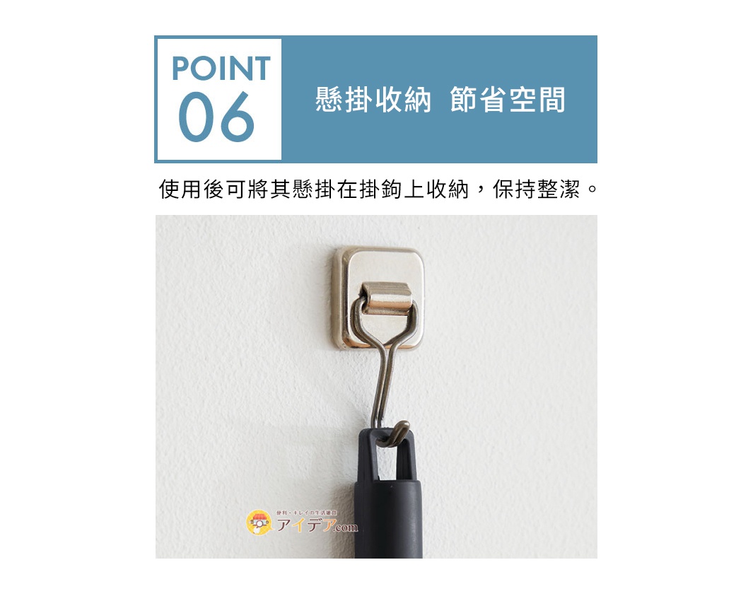 金屬掛鉤固定在白色牆壁上，鉤子上掛著黑色手柄的清潔刷。