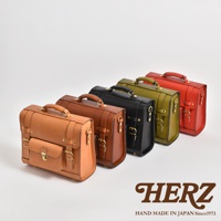 五個學院風格的皮革迷你後背包，依序為淺棕色、深棕色、黑色、橄欖綠和紅色。背包皆為皮革材質，配有頂部提把、金屬扣環和皮帶裝飾，展現職人手作質感。