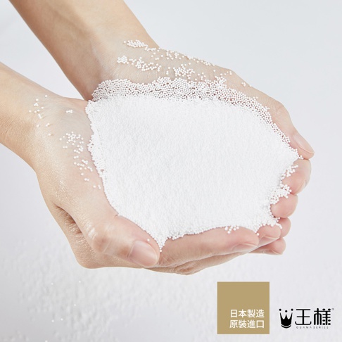 雙手捧著大量白色細小顆粒，部分顆粒散落在手上，呈現出蓬鬆的質感，背景為淺色。