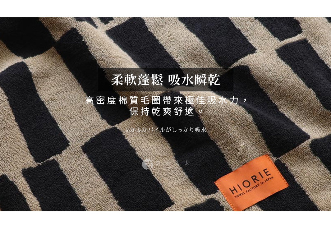 這是一條印有黑白格紋圖案的柔軟棉質浴巾，上面有中文和日文的產品說明，以及一個橘色的 HIORIE 品牌標籤。